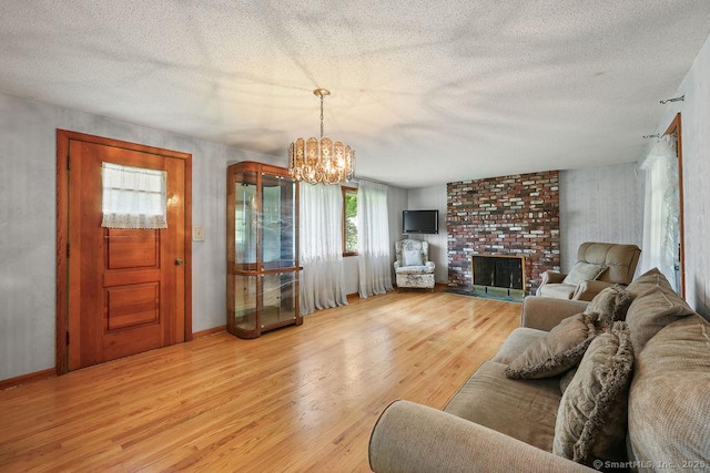 287 Prospect St, Wethersfield, CT 06109 - living area with light wood-type flooring, a chandelier, a textured ceiling, and a fireplace