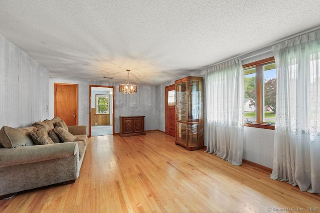 287 Prospect St, Wethersfield, CT 06109 - living area featuring a chandelier, light wood-style floors, and a textured ceiling