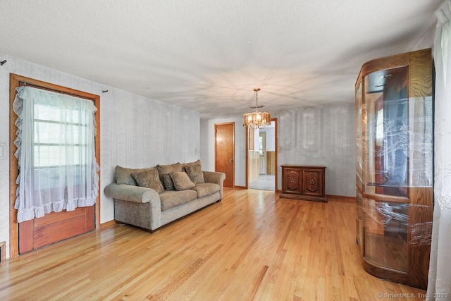 287 Prospect St, Wethersfield, CT 06109 - living area featuring wood finished floors, a chandelier, and a textured ceiling