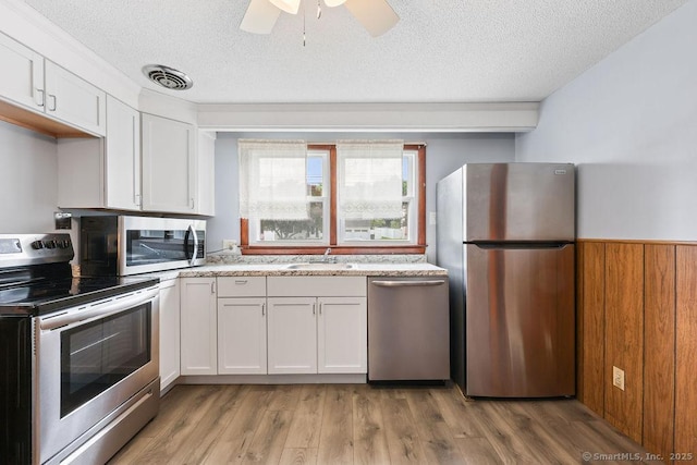 287 Prospect St, Wethersfield, CT 06109 - kitchen with appliances with stainless steel finishes, white cabinets, a sink, a textured ceiling, and a ceiling fan
