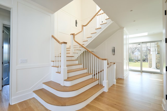 staircase with a decorative wall and wood finished floors