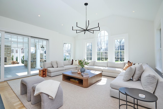 living area featuring a wealth of natural light, a notable chandelier, and high vaulted ceiling