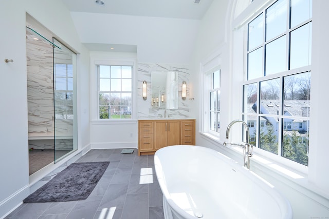 bathroom with walk in shower, a soaking tub, baseboards, and vanity