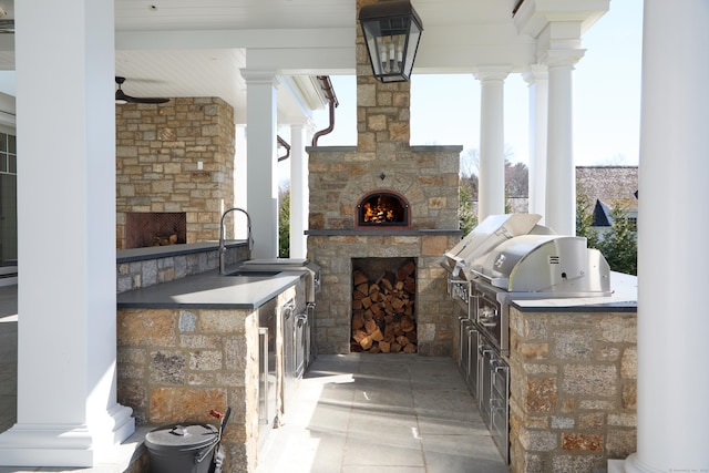 view of patio featuring a sink, grilling area, area for grilling, and an outdoor stone fireplace