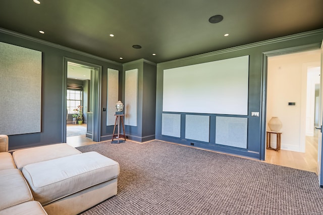 home theater room with crown molding, wood finished floors, baseboards, and recessed lighting