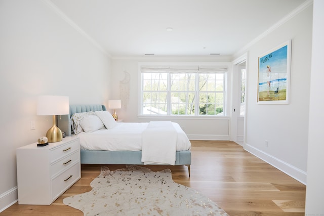 bedroom featuring crown molding, baseboards, and light wood-type flooring