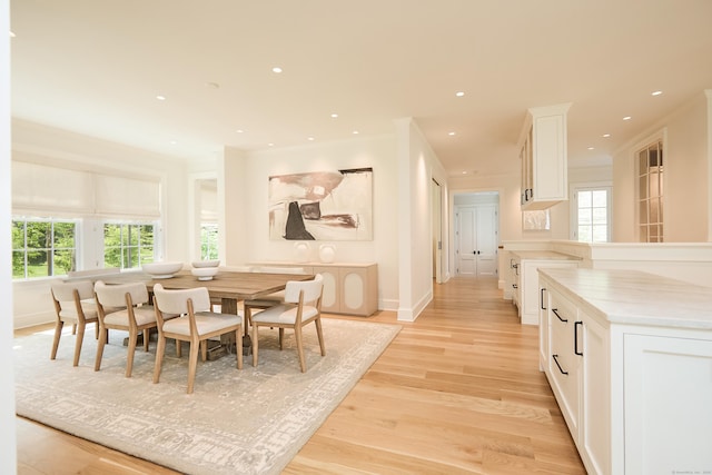 dining area featuring light wood finished floors, baseboards, and recessed lighting