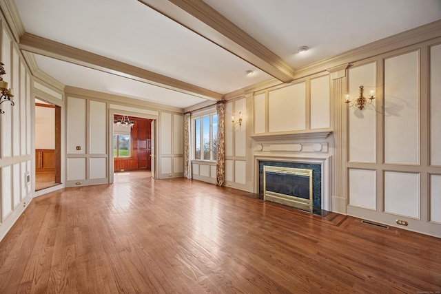 14 Turnberry Rd, Wallingford, CT 06492 - unfurnished living room with a decorative wall, light wood-style floors, a fireplace, beam ceiling, and a chandelier