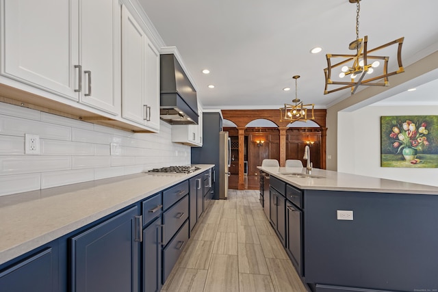14 Turnberry Rd, Wallingford, CT 06492 - kitchen with custom exhaust hood, a sink, a chandelier, tasteful backsplash, and arched walkways