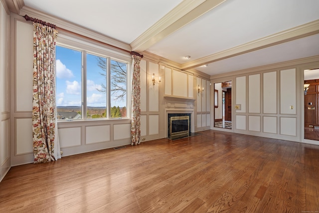 14 Turnberry Rd, Wallingford, CT 06492 - unfurnished living room featuring a decorative wall, ornamental molding, wood finished floors, a glass covered fireplace, and beam ceiling