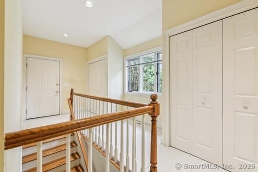 hall with recessed lighting and an upstairs landing