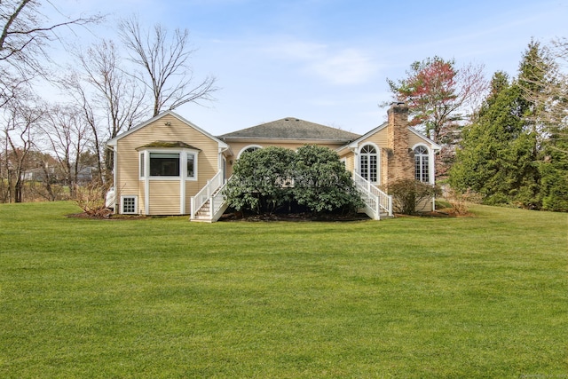 exterior space with stairs, a front lawn, and a chimney