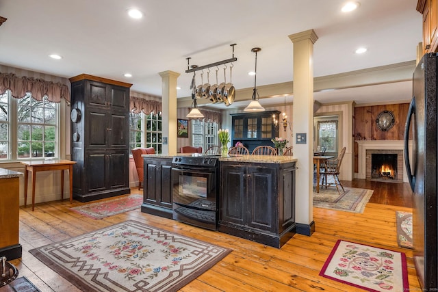 120 Boston Post Rd, Old Lyme, CT 06371 - kitchen with black appliances, ornate columns, light wood finished floors, light stone countertops, and a fireplace