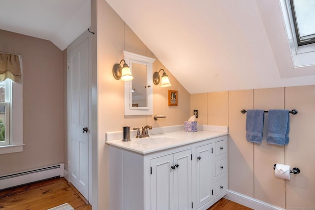 120 Boston Post Rd, Old Lyme, CT 06371 - bathroom featuring vaulted ceiling, baseboard heating, vanity, a skylight, and wood finished floors