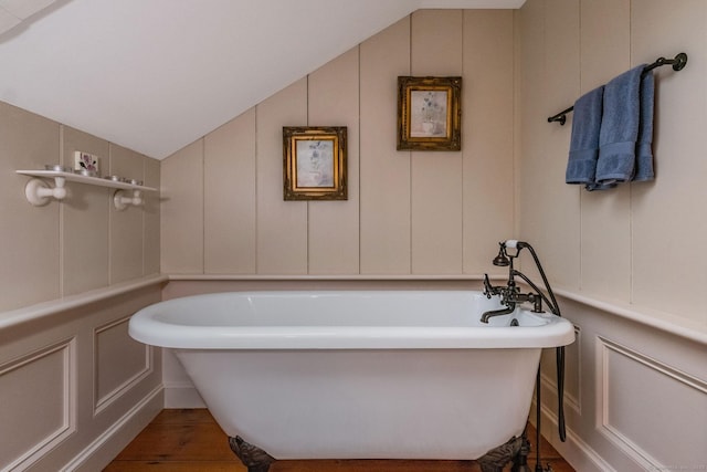 120 Boston Post Rd, Old Lyme, CT 06371 - bathroom featuring a decorative wall, lofted ceiling, a freestanding tub, and wood finished floors