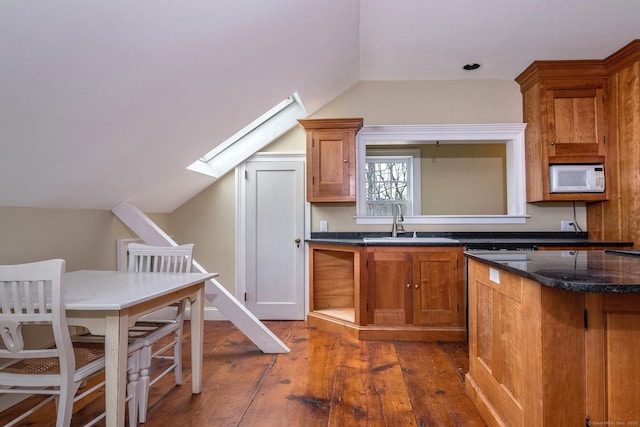 120 Boston Post Rd, Old Lyme, CT 06371 - kitchen featuring white microwave, light wood finished floors, lofted ceiling, brown cabinetry, and a skylight