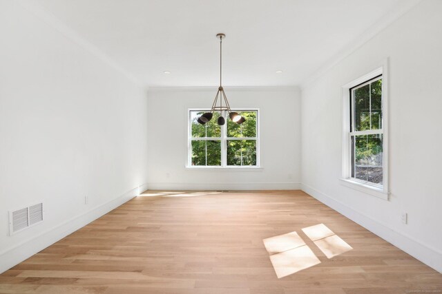 unfurnished dining area featuring visible vents, light wood-type flooring, baseboards, and ornamental molding