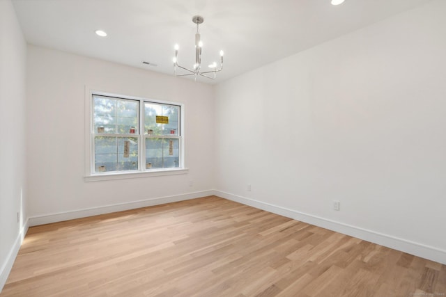 unfurnished room with recessed lighting, a notable chandelier, light wood-type flooring, and baseboards