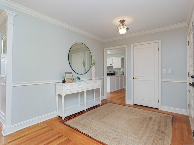 foyer entrance featuring baseboards, ornamental molding, and wood finished floors