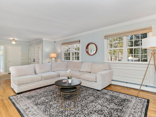living area featuring ornamental molding, a baseboard heating unit, and wood finished floors