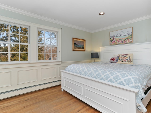 bedroom featuring light wood-type flooring, a wainscoted wall, a baseboard heating unit, ornamental molding, and recessed lighting