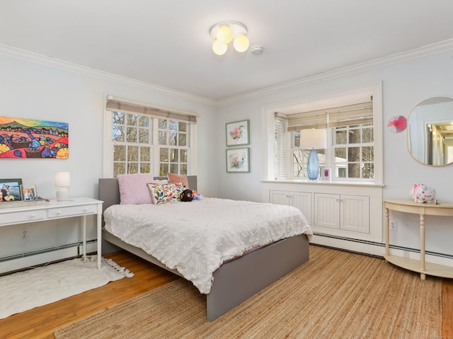 bedroom with crown molding, a baseboard heating unit, and wood finished floors