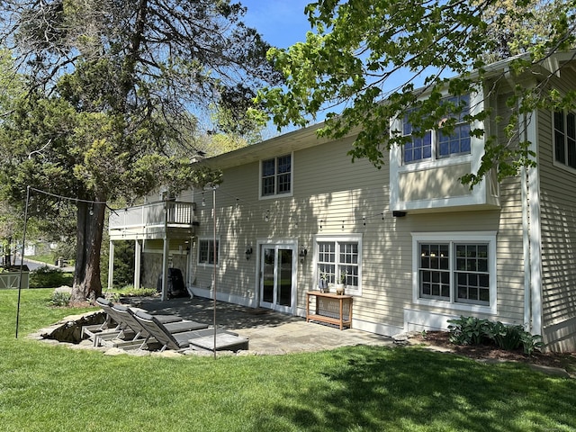 back of house featuring a patio, a balcony, and a yard