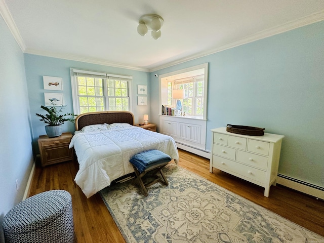 bedroom featuring crown molding, baseboard heating, and wood finished floors
