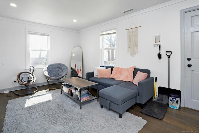 living room featuring visible vents, wood finished floors, crown molding, and plenty of natural light