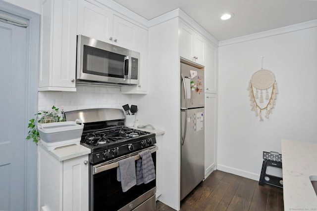 kitchen featuring light stone counters, crown molding, dark wood finished floors, stainless steel appliances, and white cabinets