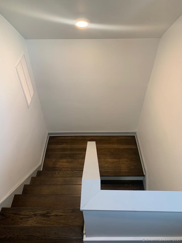 staircase with baseboards and wood finished floors