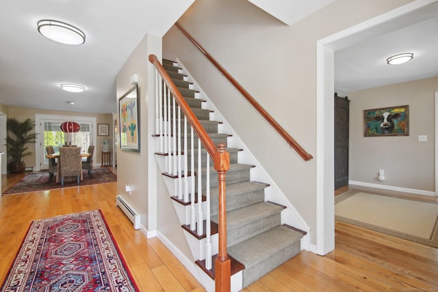 34 Kent Rd, Warren, CT 06754 - stairway featuring a baseboard radiator, a barn door, wood-type flooring, and baseboards