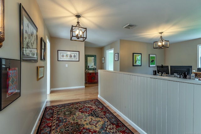 34 Kent Rd, Warren, CT 06754 - corridor with a chandelier and light wood-style flooring