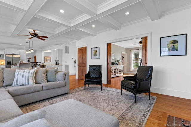 living room with beam ceiling, light wood-type flooring, a ceiling fan, and coffered ceiling