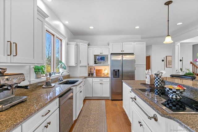 kitchen featuring appliances with stainless steel finishes, a sink, and white cabinets
