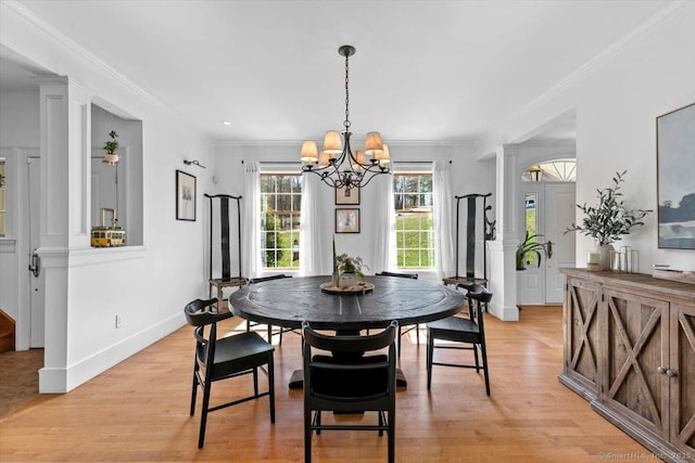 dining area with ornamental molding, light wood-type flooring, and a notable chandelier