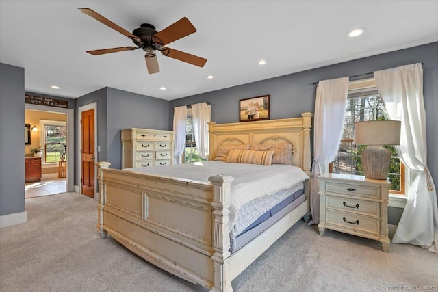 bedroom featuring recessed lighting, ensuite bathroom, multiple windows, and light colored carpet
