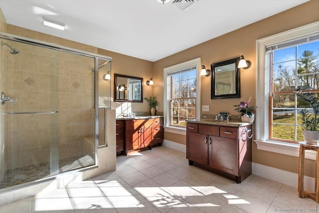 full bath featuring a stall shower, visible vents, vanity, and plenty of natural light