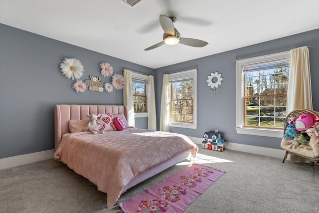 carpeted bedroom with baseboards, multiple windows, and a ceiling fan