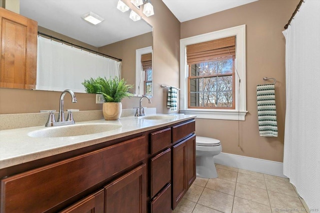 full bathroom with toilet, tile patterned floors, double vanity, and a sink