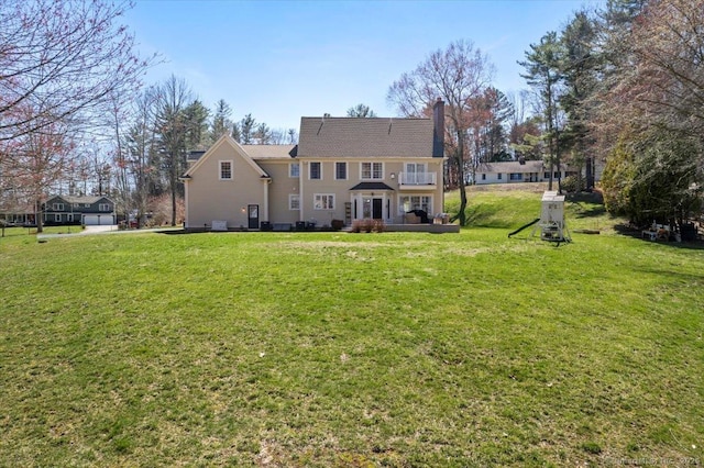 rear view of property featuring a yard and a chimney