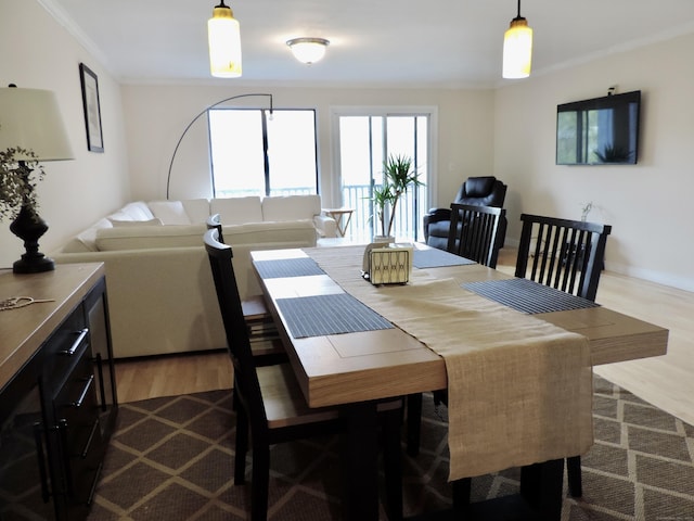 dining space featuring crown molding and dark wood-style floors