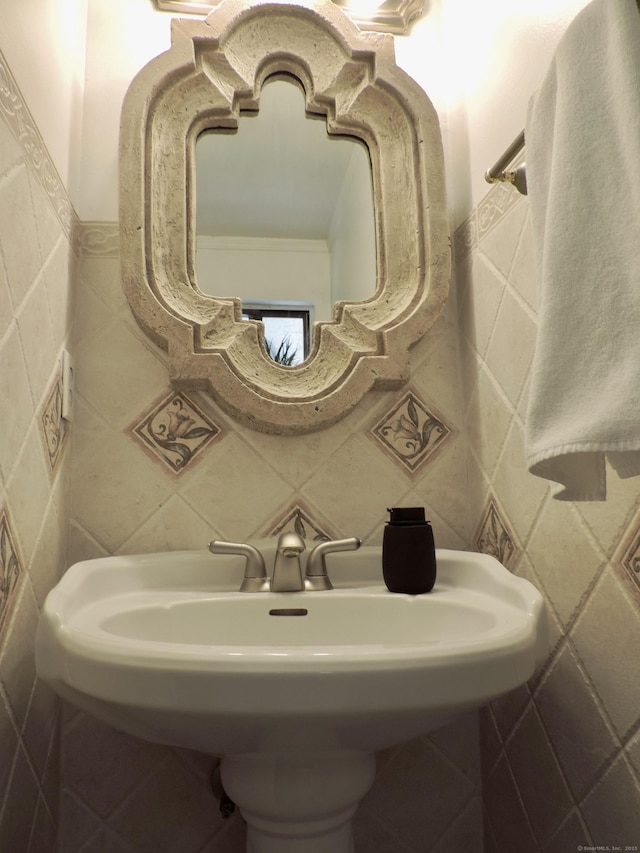 bathroom featuring a sink and tile walls