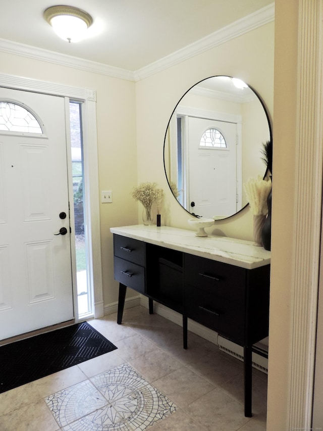 foyer entrance featuring crown molding, baseboards, and light tile patterned flooring