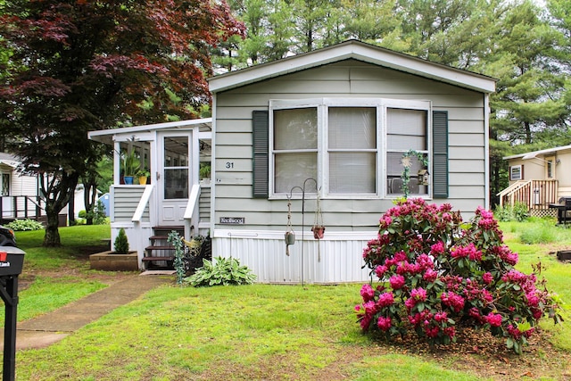 31 James Dr, Windham, CT 06256 - manufactured / mobile home featuring a front yard and a sunroom