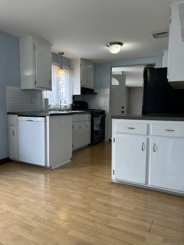 18 Nancy Dr, Enfield, CT 06082 - kitchen featuring tasteful backsplash, dark countertops, light wood-style floors, visible vents, and black appliances