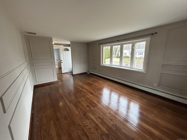 18 Nancy Dr, Enfield, CT 06082 - spare room featuring a decorative wall, dark wood-type flooring, baseboard heating, and visible vents