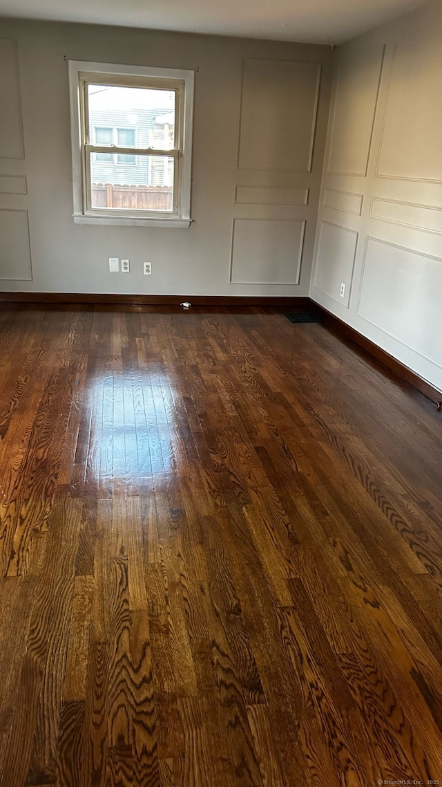 18 Nancy Dr, Enfield, CT 06082 - spare room with dark wood-type flooring, baseboards, and a decorative wall