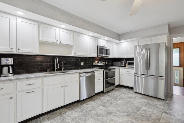 36 Musket Ridge Rd, New Fairfield, CT 06812 - kitchen featuring appliances with stainless steel finishes, white cabinets, decorative backsplash, crown molding, and a ceiling fan