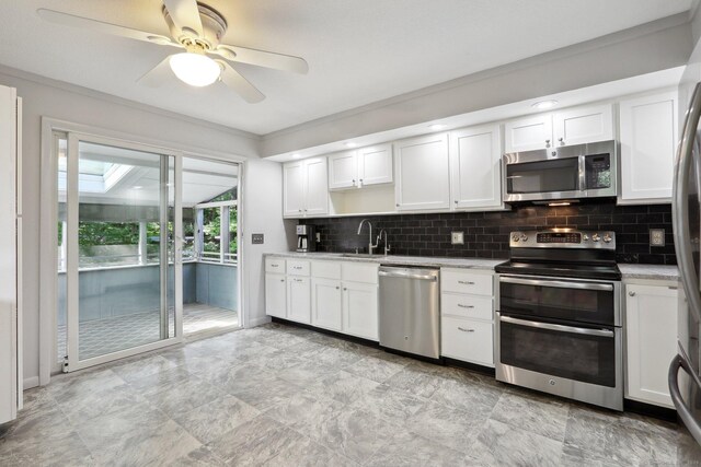 36 Musket Ridge Rd, New Fairfield, CT 06812 - kitchen with appliances with stainless steel finishes, decorative backsplash, light countertops, crown molding, and white cabinetry